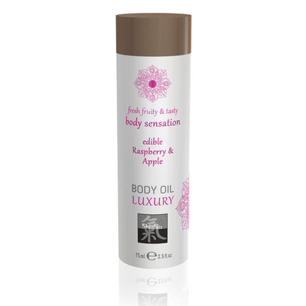 A bottle of SHIATSU Edible Body Oil with Raspberry & Apple flavor. The packaging is white with a purple cap and has text describing the product as luxury, fresh, fruity, and tasty for body sensations.