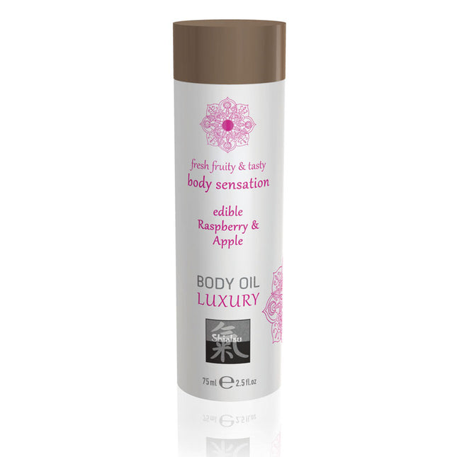 A bottle of SHIATSU Edible Body Oil with Raspberry & Apple flavor. The packaging is white with a purple cap and has text describing the product as luxury, fresh, fruity, and tasty for body sensations.