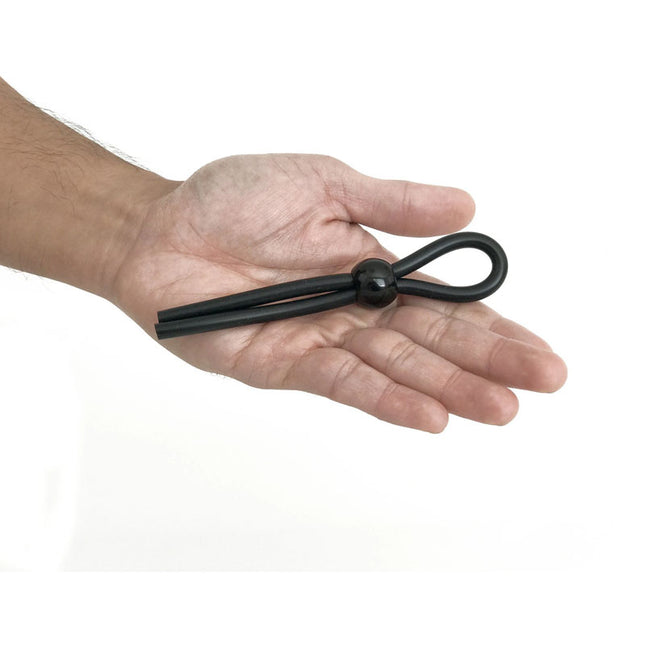 Black metal knot held in a hand on a white background