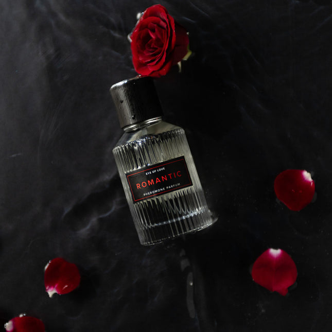 Perfume bottle labeled 'Romantic' with a red rose on a dark background