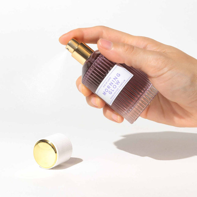 Hand holding a skincare bottle labeled 'Morning Glow' on a white background