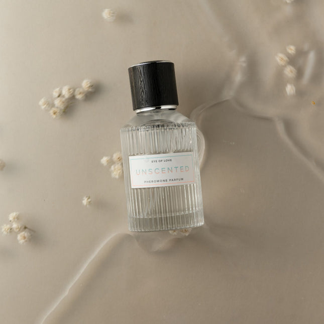 Eye Of Love Unscented Pheromone Perfume - 50ml with a black cap on a beige background with small white flowers.