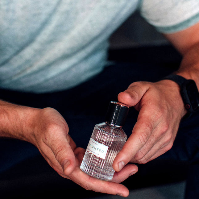 Person holding a small bottle of Eye Of Love Unscented Pheromone Perfume - 50ml with a focus on the product.