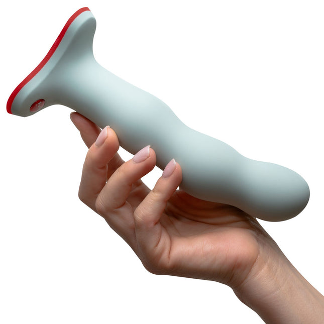 hand holding a FUN FACTORY BOUNCER Sage Green – Strap-On 7 Inch Dildo on a white background