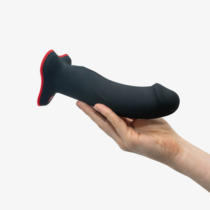 hand holding FUN FACTORY THE BOSS Black – 7 Inch Strap-On & Suction Dildo