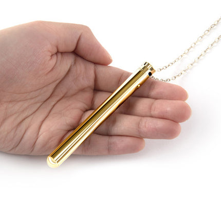 Female hand holding Gold Sex Toy Necklace Vibrator