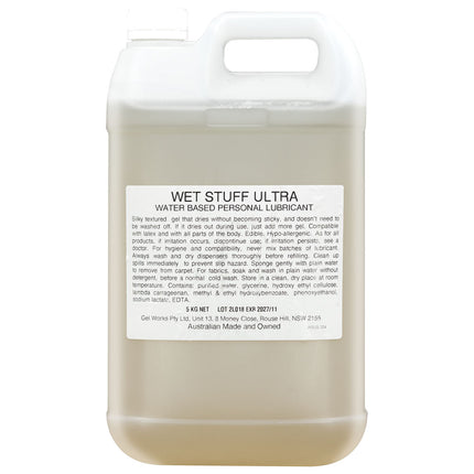 A 5 kg bottle of Wet Stuff Ultra water-based personal lubricant with a beige label and clear liquid visible through the bottle.