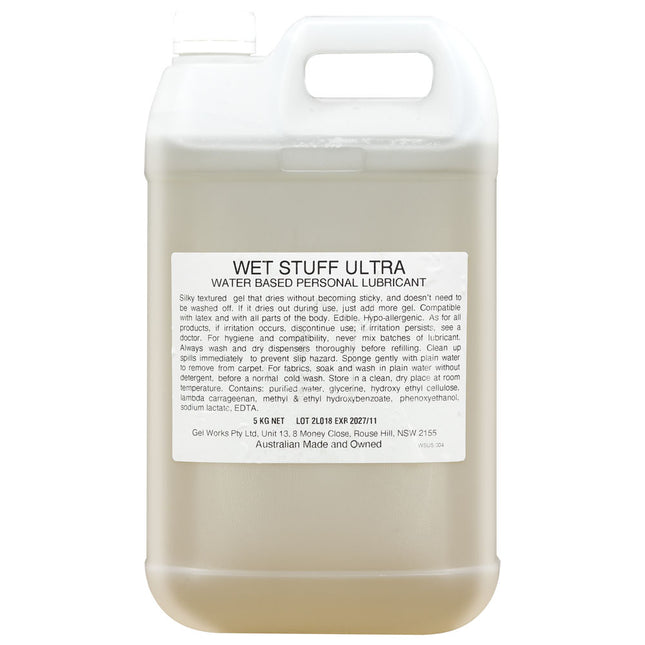 A 5 kg bottle of Wet Stuff Ultra water-based personal lubricant with a beige label and clear liquid visible through the bottle.