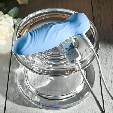 Top View of Gender X LIL BUDDY Light Blue Rechargeable Mini Bullet Vibrator on Clear Stand