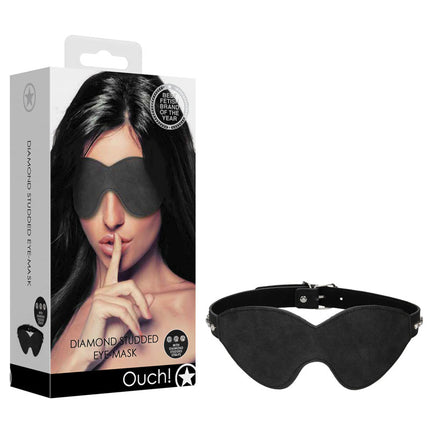 A black faux leather eye mask with diamond studs, displayed next to its packaging which features a woman wearing the mask. The packaging has the brand 'Ouch!' visible.